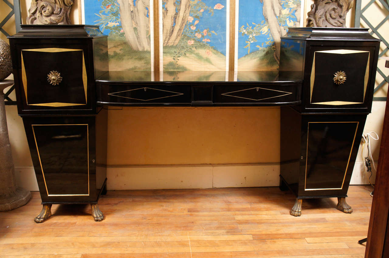 This sculptural and dramatic sideboard made in this country in the Hollywood Regency style most associated with the industry and stars of the big screen in the 1930s and 1940s. Of a regency form, the sideboard consists of a large slab center section