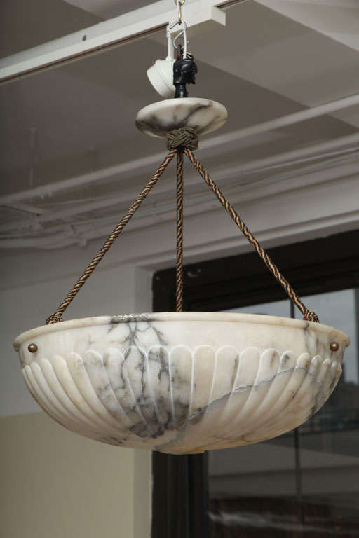 A continental white and veined alabaster pendant, Early 20th Century<br />
<br />
Of dish form with gadrooned carving