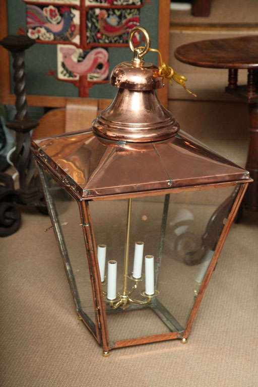 A near pair of coppers hanging lanterns with bell tops over trapezoidal plates, by W. Edgar and Son Ltd, with original brass label (on one) reading 