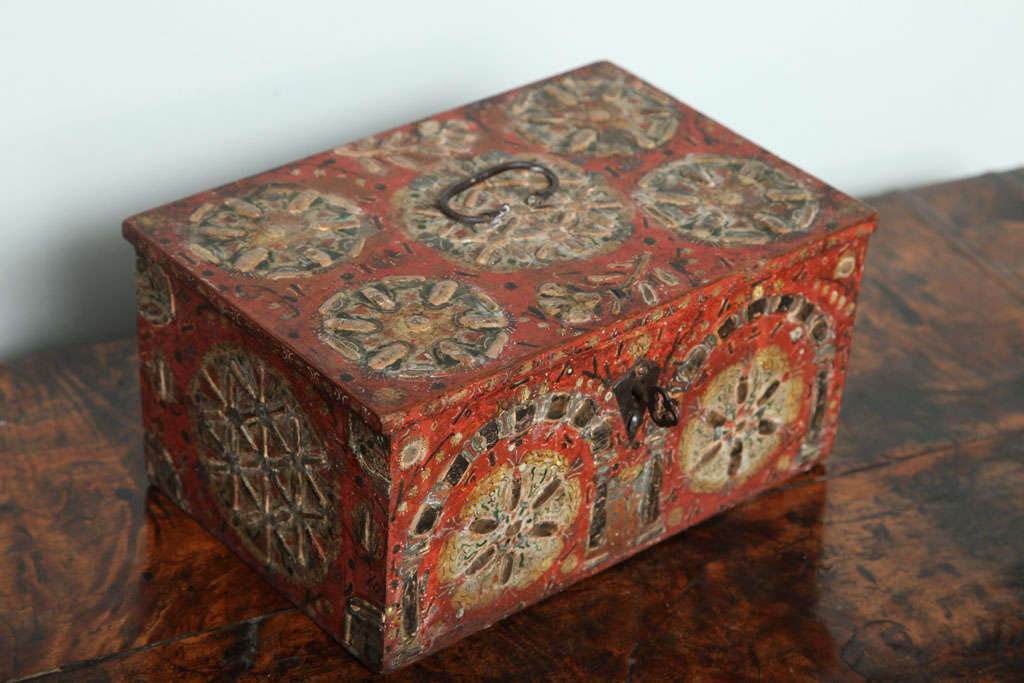 Very early paint and gesso decorated box, the wire hinged and handled top with flower head design, the petals executed in raised gesso and decorated in burnished (and now tarnished!) silver leaf on a red ground, the sides, back and front similarly