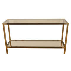A Jansen Two Tiered Two Tone Brass and Smoked Glass Console.