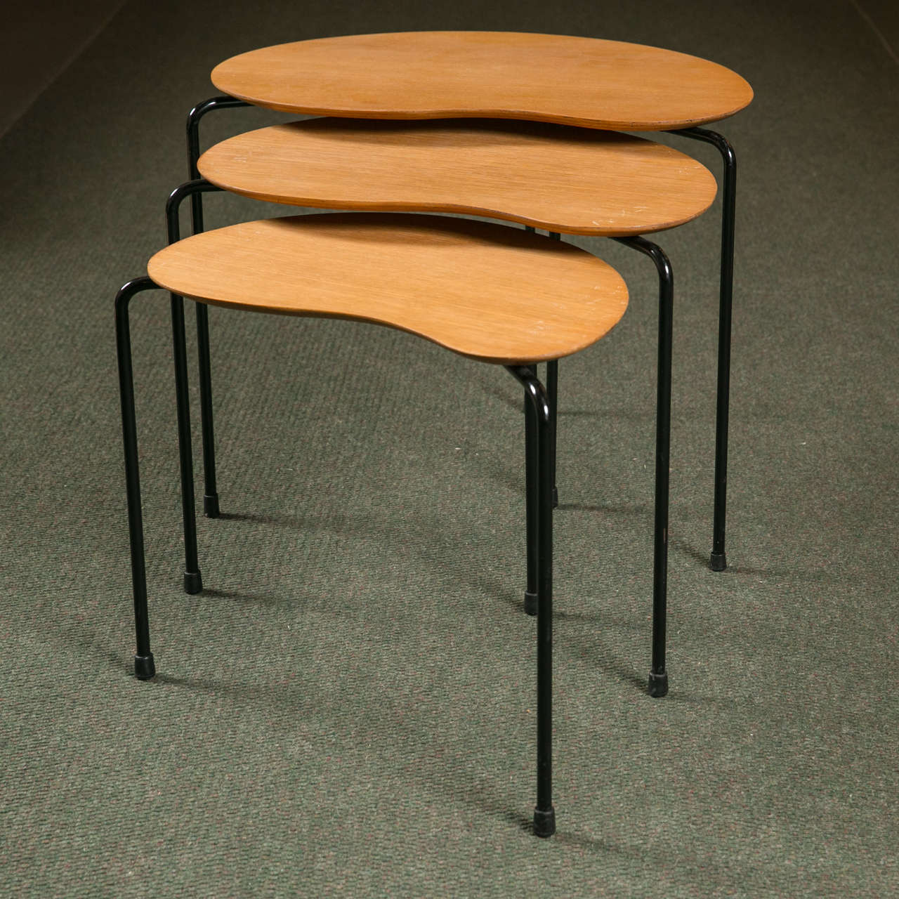 A Mid-Century Modern set of three nesting tables in laminated oak.
