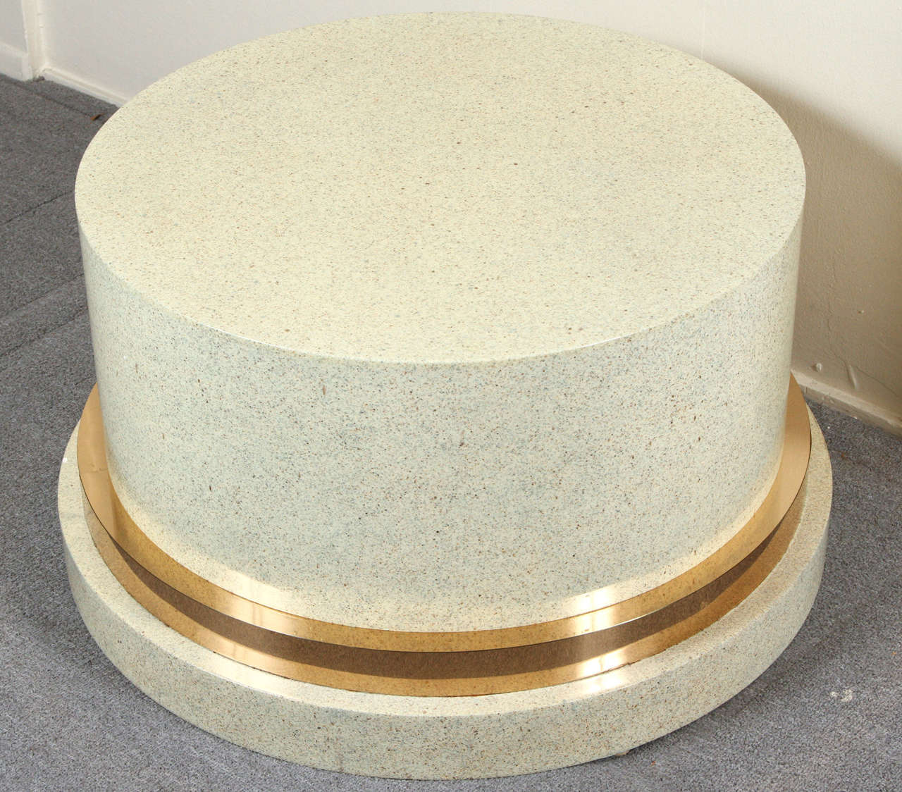 Low pedestal, which may be used as a coffee table base.
It is of wood with a faux stone finish and brass accent.
The table has a 36