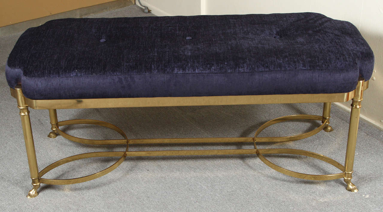 Very nice brass bench with midnight blue chenille upholstery.

The graceful brass base is finished off with hooves.