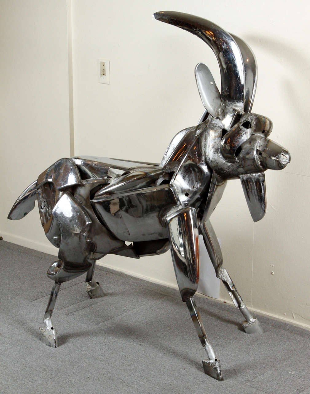 Fabulous chrome goat. Large sculpture by John Kearney.

Mr. Kearney was famous for his droll and amusing sculptures of animals made from discarded car bumpers and chrome parts. They are life sized and surprisingly beautiful and realistic, given