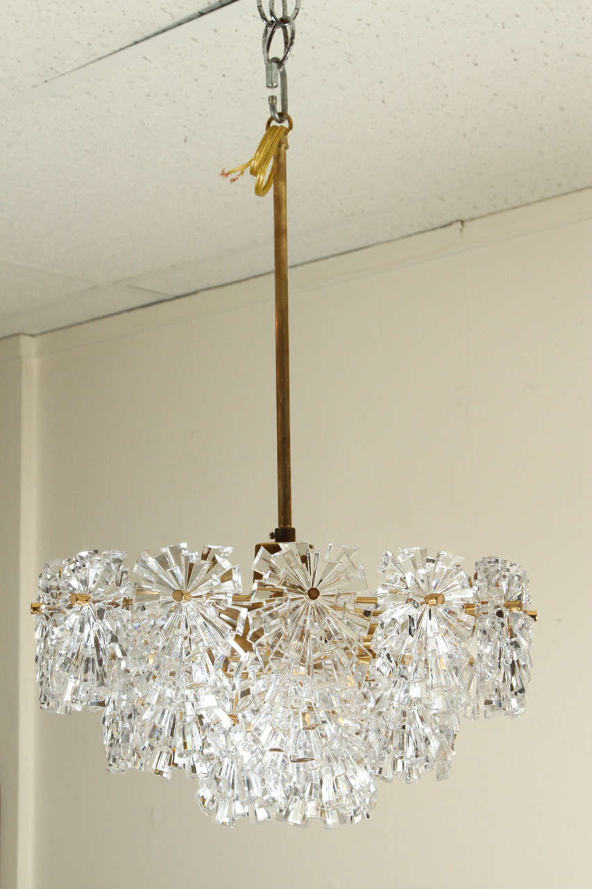 Charming chandelier by Kinkeldey.
The frame is brass and the crystal elements have many sharp facets for a glittering effect which when illuminated is stunning
The chandelier itself has an 8