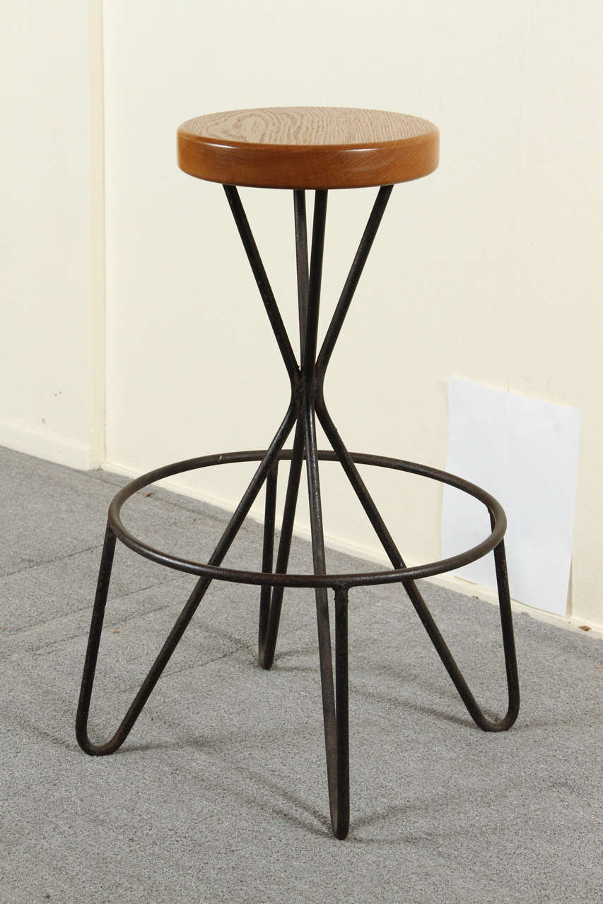 Four beautiful iron bar stools with solid oak seats. These are hand-wrought, with small variations in the bases.
The seats are 11 inches in diameter, the foot rests are 17 inches in diameter.