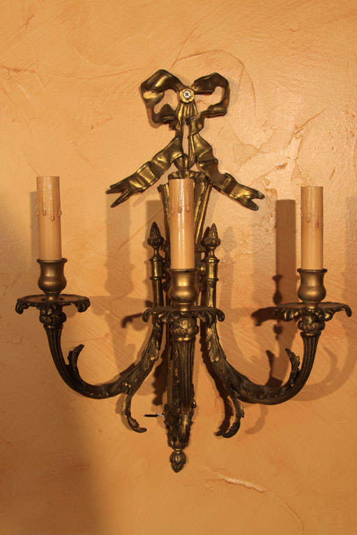 French Louis XVI Style Sconces

This is a nice pair of three-arm, Louis XVI sconces with ribbons. They were originally wired for gas, but have been converted to electricity (US) and are ready to install.

They have traces of gilt over bronze