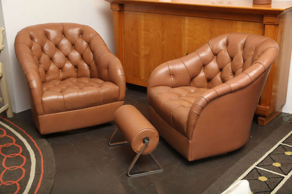 WARD BENNETT (1917 - 2003)<br />
Pair of button-tufted lounge chairs <br />
In caramel leather on swiveling bases.<br />
with fabulous bolster ottoman.<br />
American, c. 1965