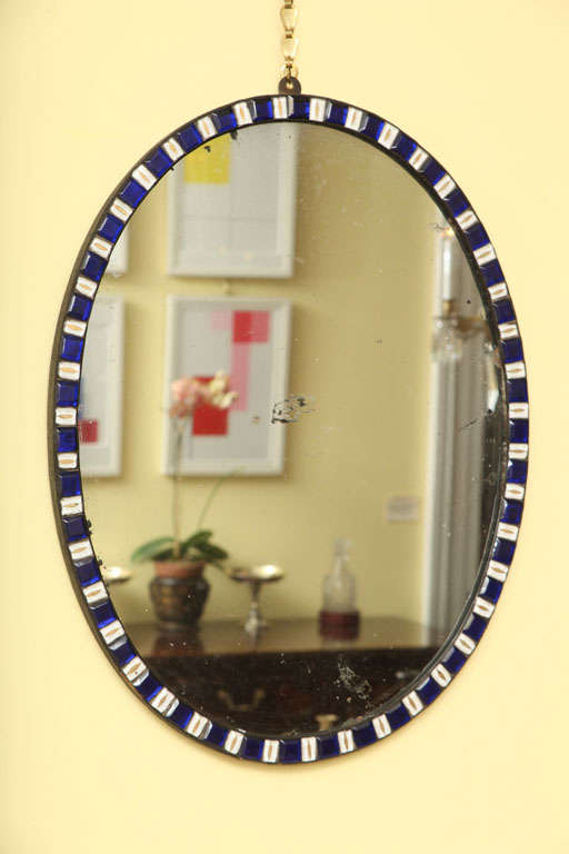 Fine and rare 18th century Irish oval mirror, the copper frame with faceted ring-set sapphire blue glass jewels alternating with white and gilt enameled jewels centering the original silvered plate, Irish, circa 1785