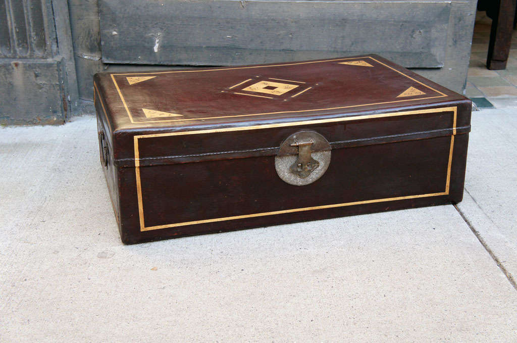 This truck in a rich deep brown lacquered pig skin is in great shape and retaining all of the gilded details. The simple form used as traveling trunks for the common man of the era usually are very distressed and damaged thru use. Excellent to use