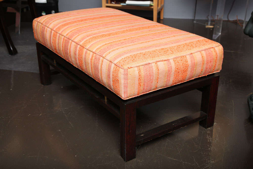 Edward Wormley
Low bench raised on dark walnut base with brass details. Upholstered in original woven coral and clementine striped fabric. Signed with metal label underneath.
Executed by Dunbar
American, circa 1950.