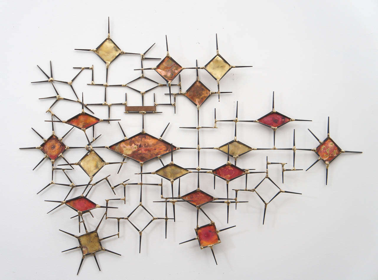 This fabulous metal wall sculpture really captures the mid century modernism feel. I believe it predates the Curtis Jere phenomenon with a more futuristic look
indicative of that time period.