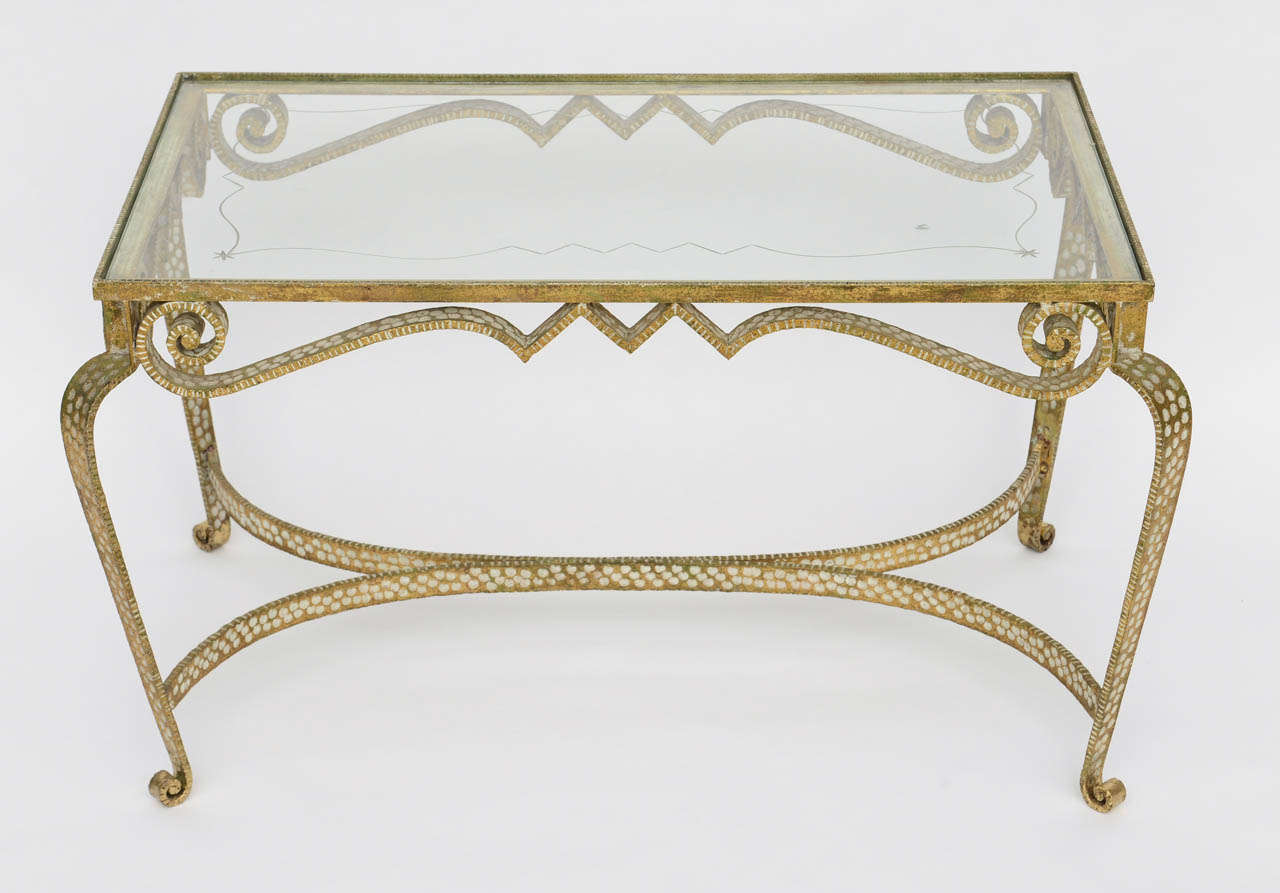 The rectangular glass inset top with scrolling gilt iron frame on cabriole legs joined by a stretcher.