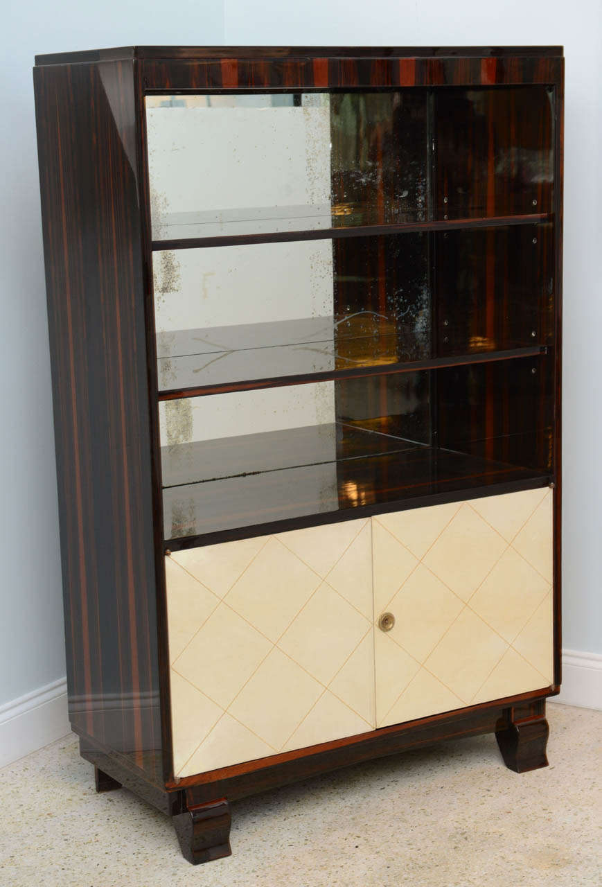 The ebony de Macassar framework with open shelves and mirror back over two doors in parchment and embossed over short cabriole legs.
Provenance: Christies, New York.