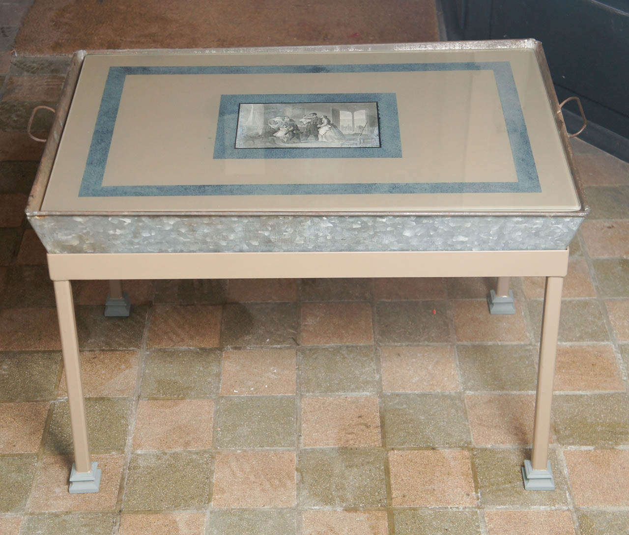 This fun old table made in the 40's shows a talented and crafty hand at work creating a one of a kind small cocktail table. The tray is a nice old galvanized  metal with all its surface in place the glass top made for it is decopaged with a 19th