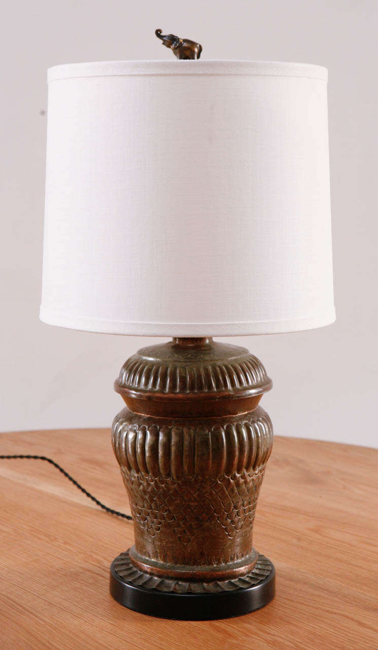Charming urn shaped table lamp with elephant finial. Newly rewired with black silk twist cord. White drum shade (11