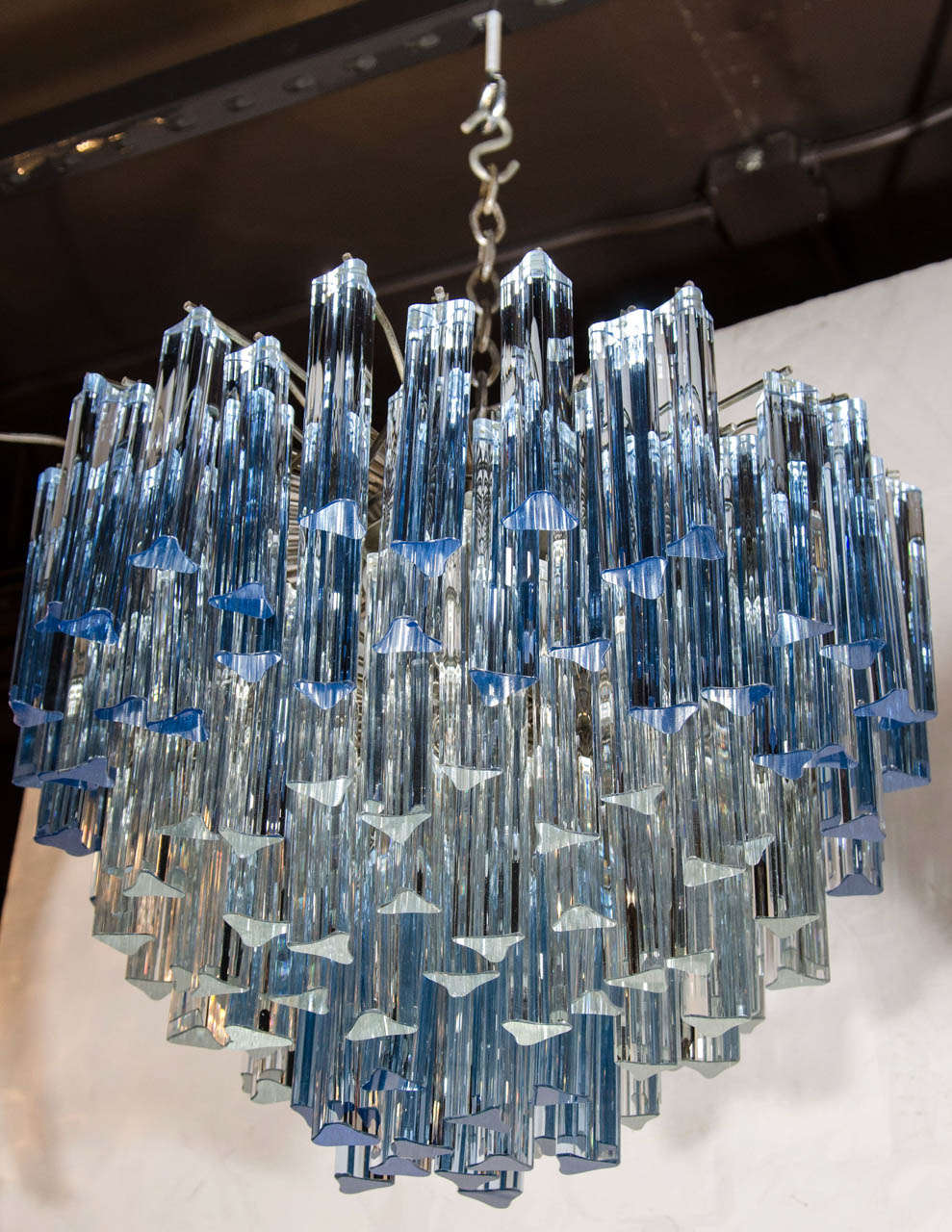 Stunning chandelier comprised of a multi tiered chrome frame with hundreds of Murano glass crystal prisms hanging at varying heights.  The crystal prisms are hand blown and have stylized triangular forms in both clear crystal and gradient hues of