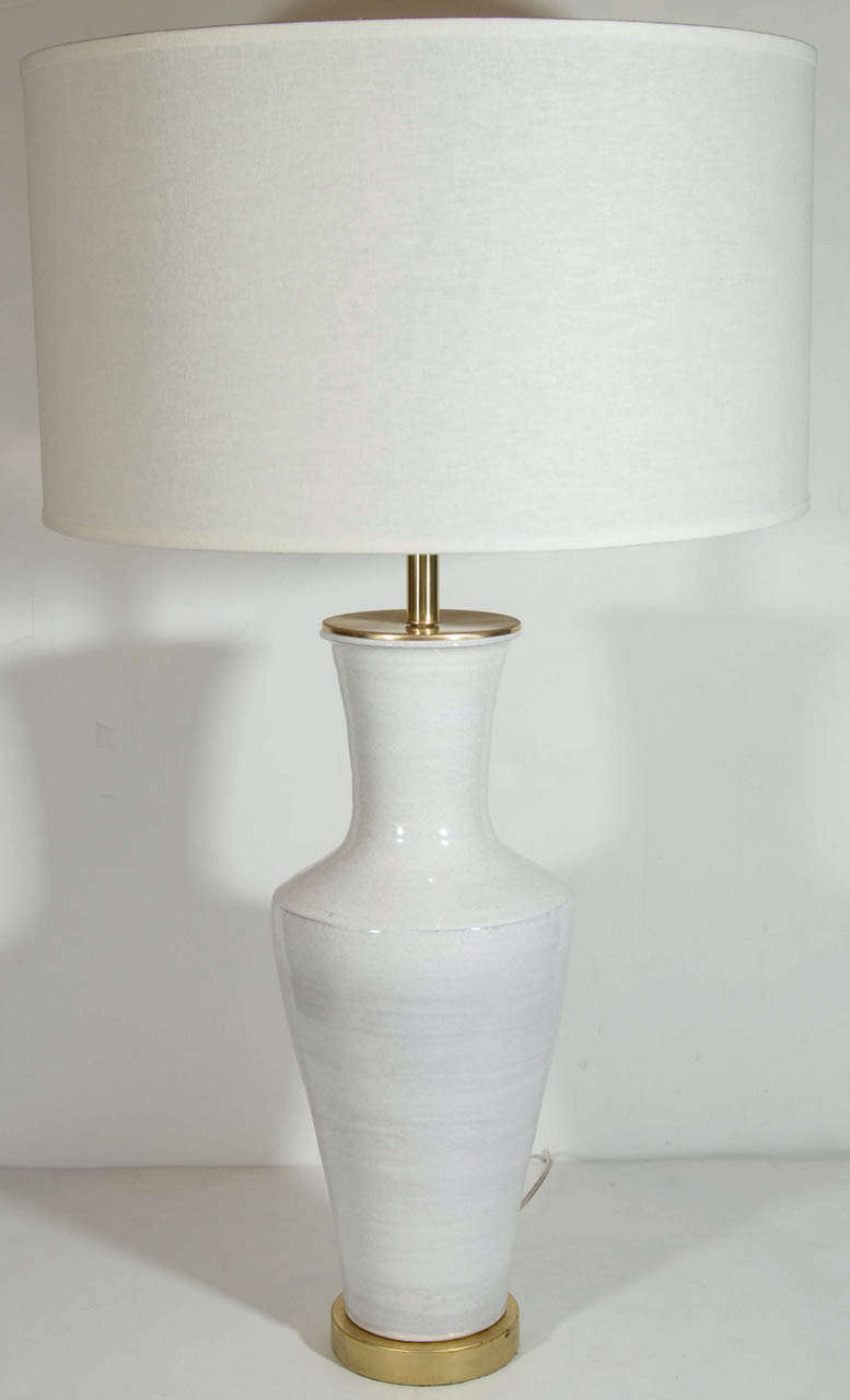 Pair of exquisite and fine terra cotta pottery lamps with horizontal white glaze finish with decorative crackles . The lamps have an Asian urn vase inspired design and are hand turned with flat shoulder details. This is a custom design from the