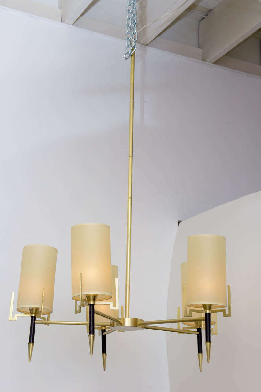 This amazing Light Fixture has a brushed brass finish to the frame , the arms are covered in leather and the  shades are all done in an oatmeal paper. There is a simple understated elegance to this chandelier great for any Interrior . Diameter is