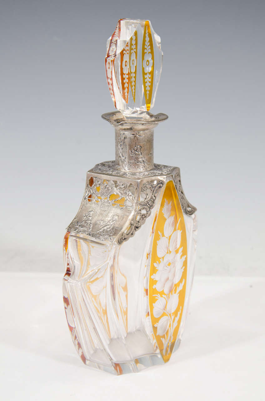 A vintage c. 1910 crystal and amber color decanter with etched design of roses on the front, and Continental Silver overlay with scenes of cherubs.  Good vintage condition with age appropriate patina.