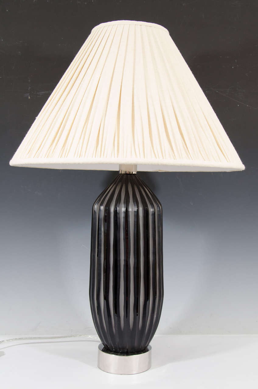 A contemporary pair of hand cut art glass table lamps with black stripe design and nickel hardware.  Shades included.