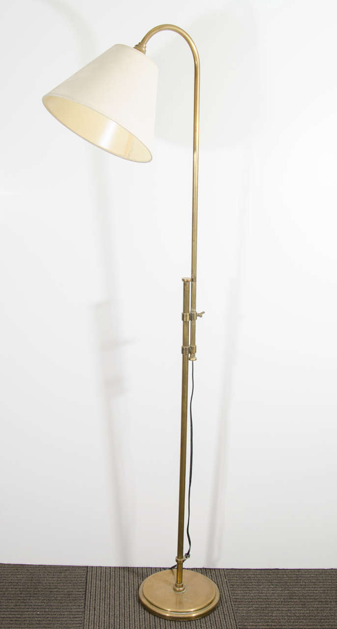 A vintage floor lamp in brass with adjustable pole, produced circa 1950s - 1960s.  Good vintage condition with age appropriate patina.