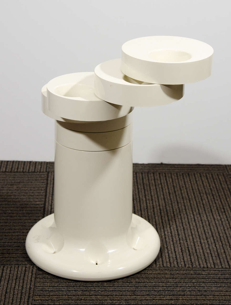A vintage white Pluvium umbrella stand by Giancarlo Piretti for Anonima Castelli.  The stand opens up to hold six umbrellas. The base is flared and features divots where the umbrella points sit. Marked on the bottom.Good vintage condition with a few