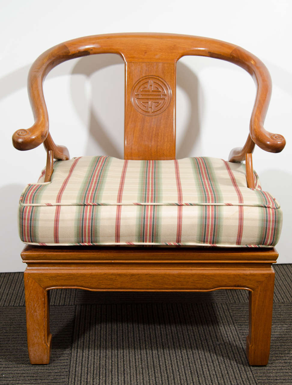 A pair of solid Chinese rosewood carved horseshoe-shaped armchairs with cushions.