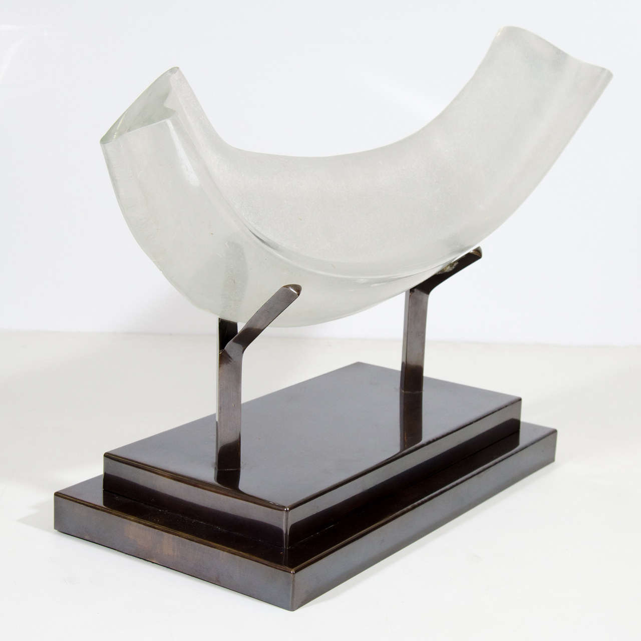 A modern multilayered thick glass organic or fossil like sculpture on a bronzed metal base attributed to Dorothe van Driel.