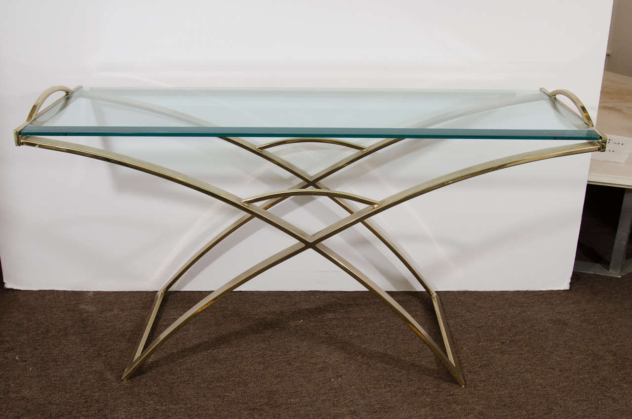 A vintage console table, produced circa 1970's, with curved X form base and glass top, flanked by two handles.  Good vintage condition with age appropriate wear and nice patina.