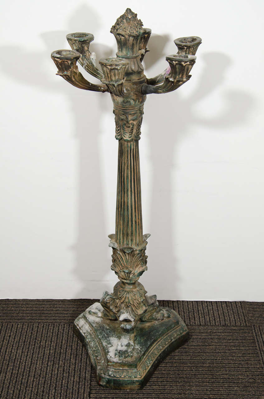 An antique pair of monumental bronze six-light candelabras, decorated with masks of kings, on animal paw feet. Good antique condition with age appropriate patina.