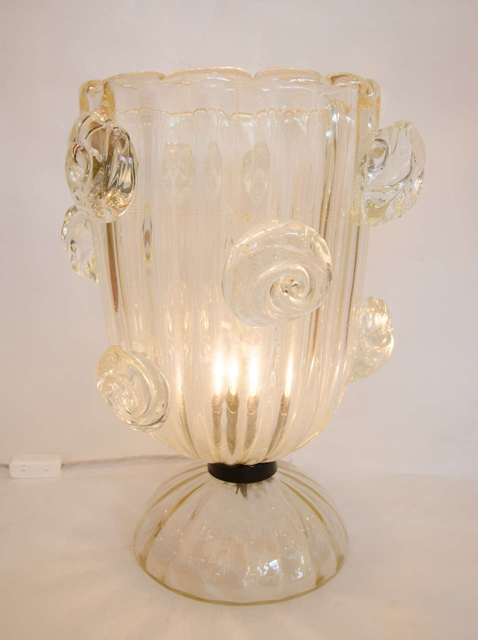 Substantial table lamps in the shape of large vases scattered with
decorative glass roses sitting on a fluted glass base