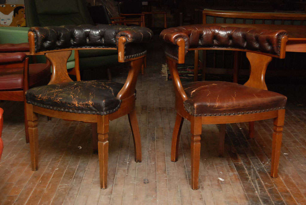 Pair of English oak library chairs with tufted leather back rails, leather seats nailed with brass studs.