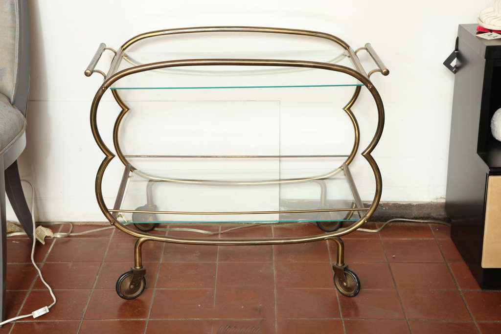 Gorgeous Mid Century Modern Bronze Bar cart. The silhouette is organic and simple. Perfect for entertaining and decorating.
The glass shelves bring an open flow. Great piece for a bachelor pad or for a small apartment.