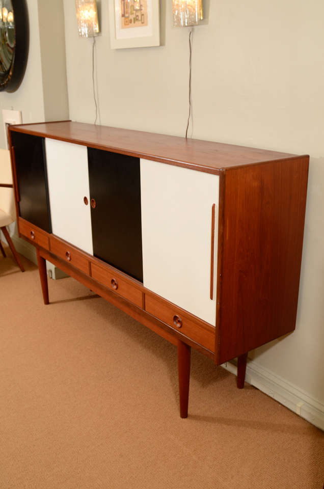 Unusual Sideboard with black and white doors is a great statement piece.  In excellent condition and a beautiful example of Mid-Century design.  An abundance of drawers and shelves will maximize storage.