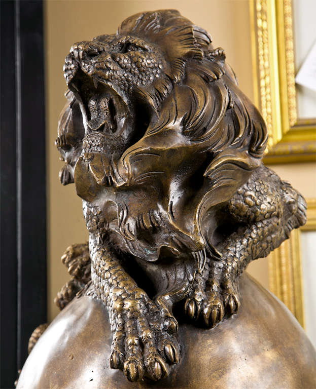 Pair of attractive bronze facing lions raised on a pair of columnar fluted pedestals. 