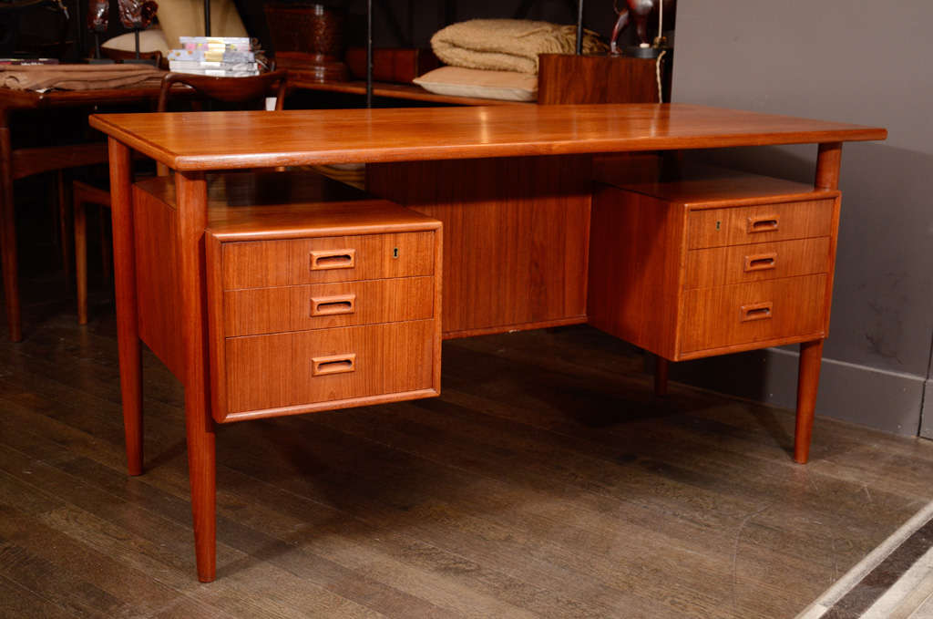 Mid Century teak desk designed by Arne Vodder. Six drawers serve the seated side with additional shelving on the opposite side of the desk. Great for an open office plan and in the middle of the room, this classic design also has spacing above