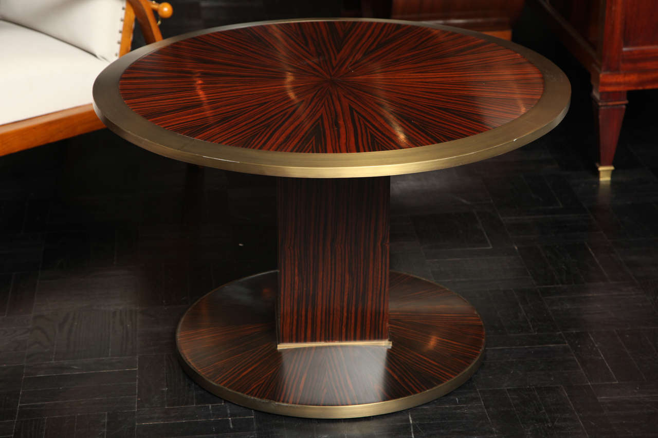 Macassar and ebony pedestal table with bronze lip and shoe.