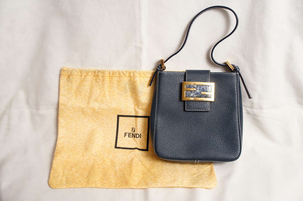 Fendi navy blue fine quality small leather handbag with interlocking
"F" metal clasp. Small afternoon or evening bag. Includes
dust cover. Never worn.