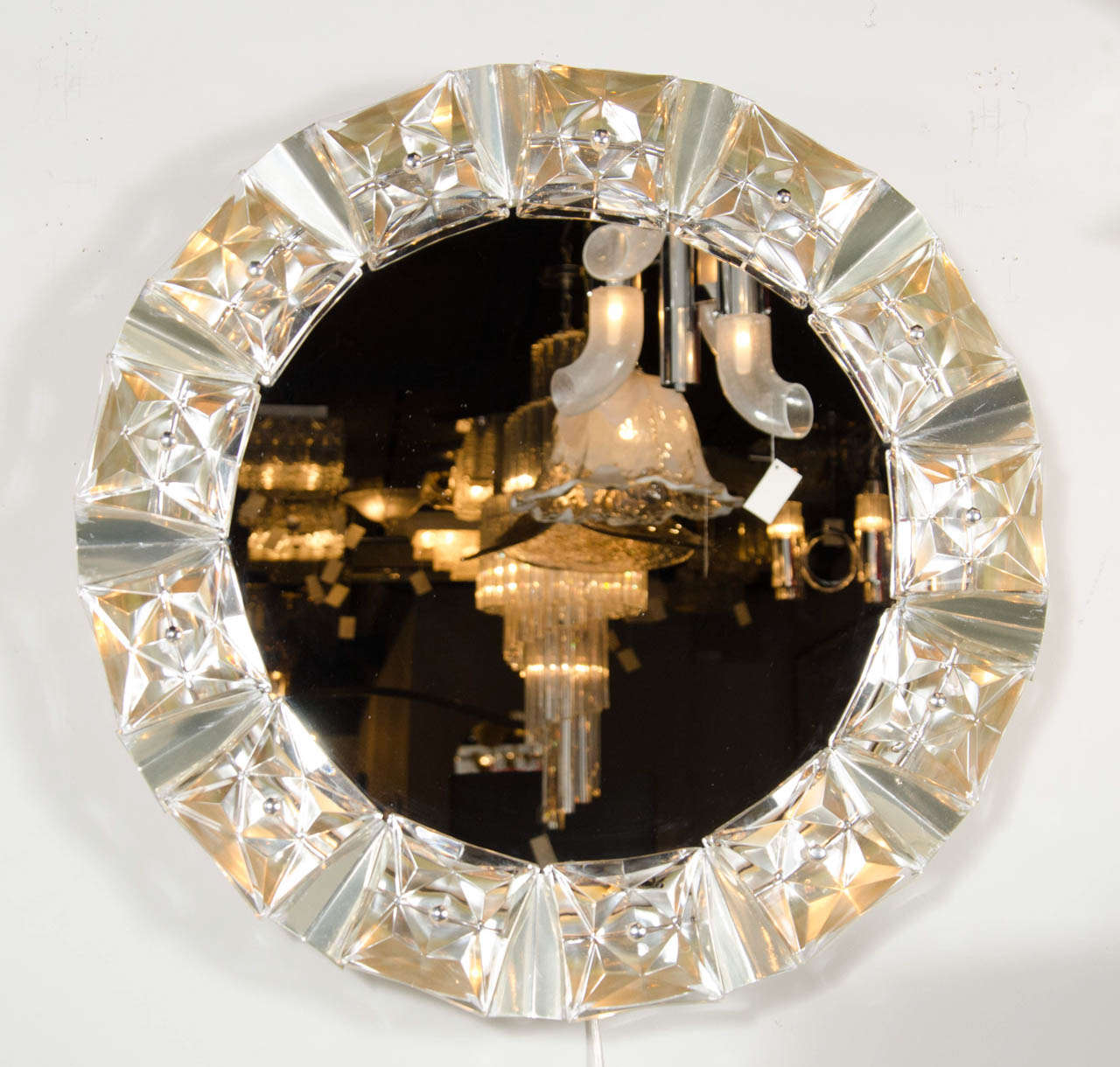 This brilliant mirror is inset with a surround of cut crystal fittings with an illumination behind.The fittings are silvered and this mirror is in mint condition.This mirror is perfect for a powder room or vanity.