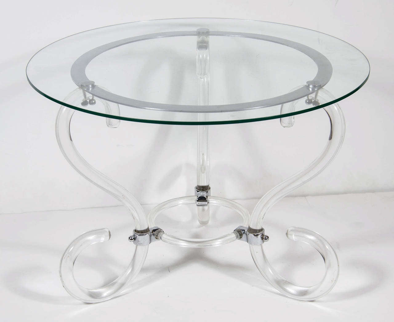 This special table features a three leg scroll form design with chromed supports and a round glass top.