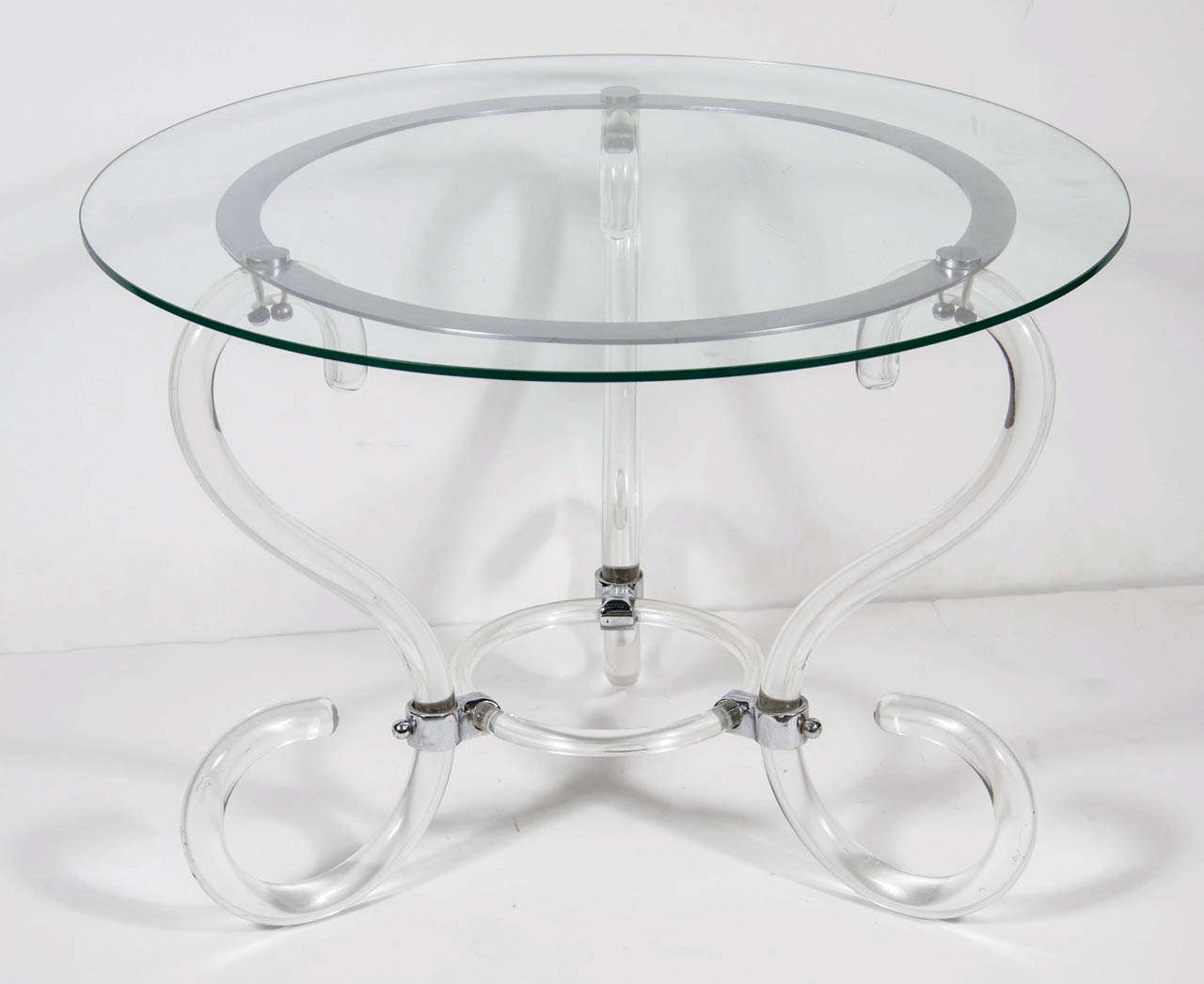 This special table features a three leg scroll form design with chromed supports and a round glass top.