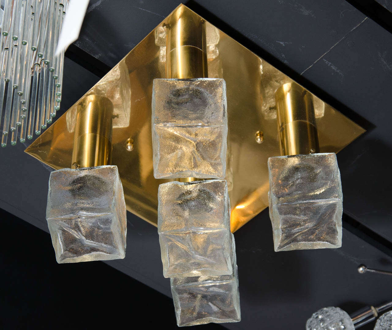 This brilliant midcentury flush mount chandelier was realized by the esteemed Austrian producer J.T. Kalmar, circa 1960. It features a square polished brass frame with five cylindrical arms in the same material that connect to handblown Murano
