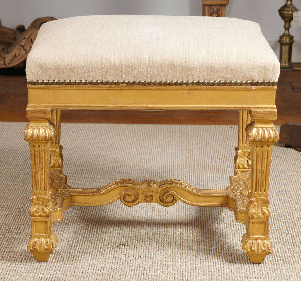 Nice Louis XV style giltwood stool. Linen upholstered top with nail-heads over a  plain frieze raised on four carved legs and feet united by a shaped stretcher.