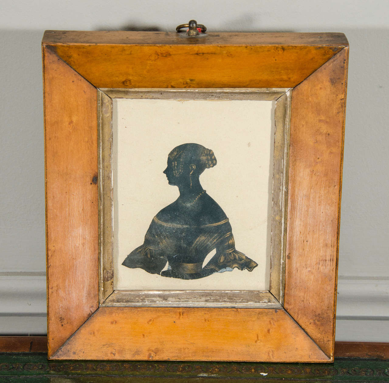This framed mid-19th century Scherenschnitte style Silhouette portrait is enhanced by hand-sketched details illustrating a victorian braided hairstyle, jewelry and off-shoulder dress. A charismatic piece of Folk Art in the original wooden frame.