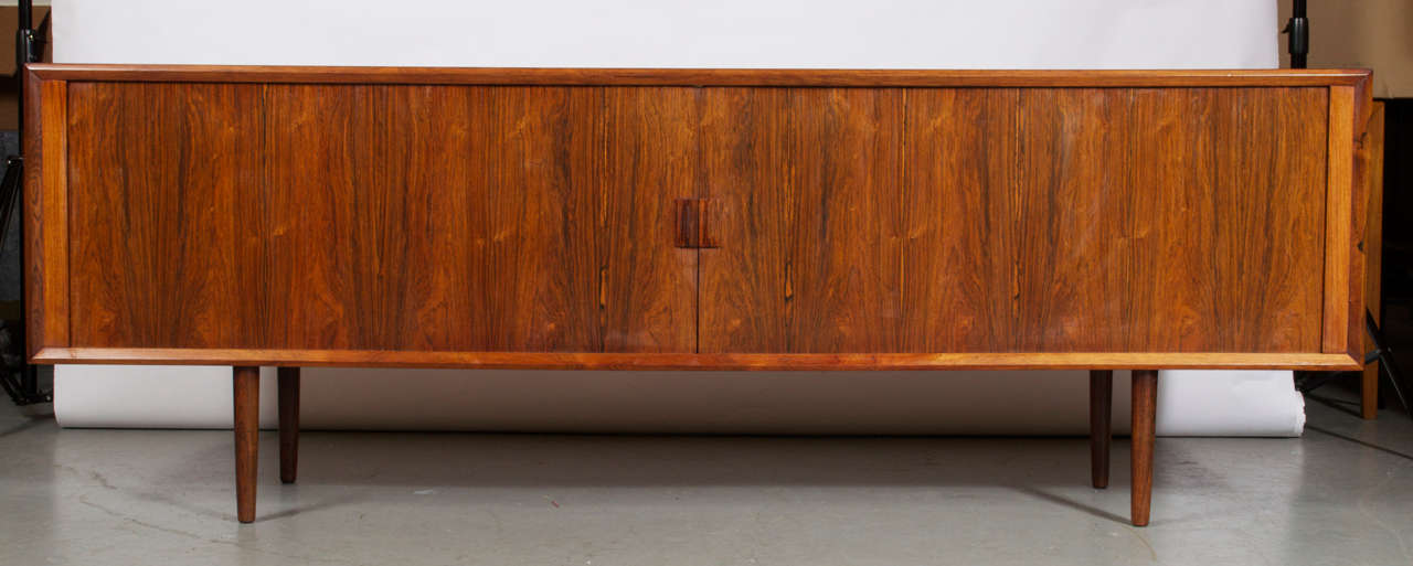 Svend Aage Larsen. Low rosewood sideboard model 49, front with two sliding doors enclosing sliding trays and shelves. Designed in 1960. Produced by Faarup Møbelfabrik.