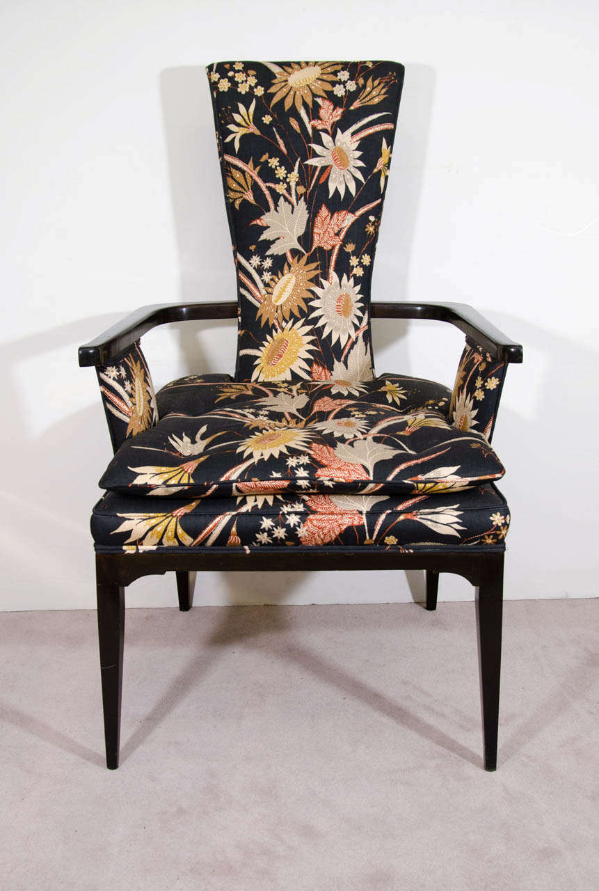 A vintage pair of high style Hollywood Regency armchairs in the style of Tommi Parzinger with ebonized hardwood and a floral patterned upholstery. 

In good condition with age appropriate wear.