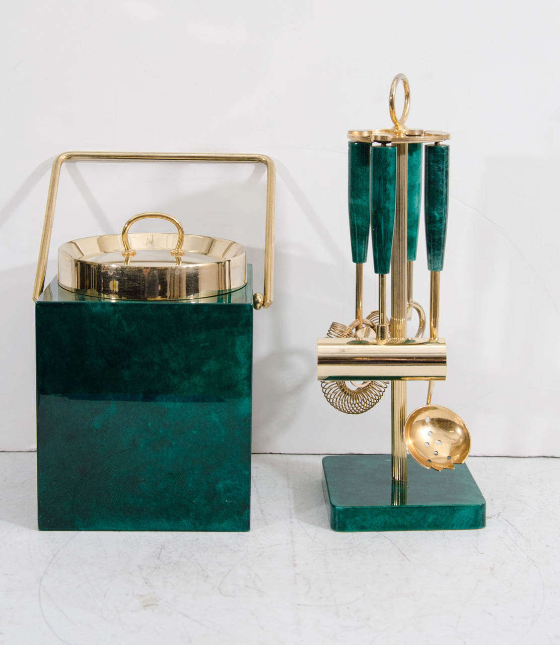 A vintage four piece bar tool set and ice bucket in brass and green lacquered goatskin by Aldo Tura.

Ice bucket is 10