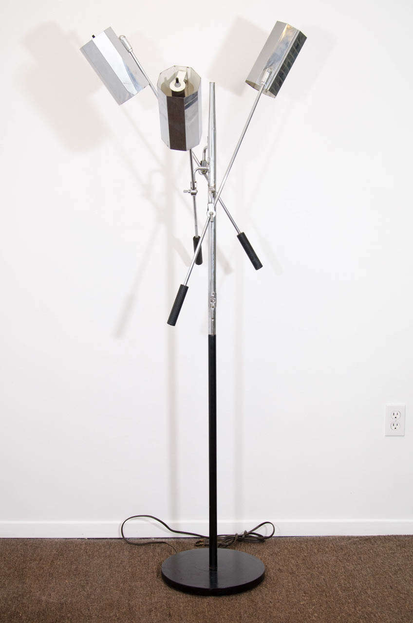 A vintage Arteluce adjustable floor lamp in chrome and enamel, by Gino Sarfatti.  The three arms can be adjusted and locked, and the chrome-faceted shades are also mobile. 

In vintage condition with age appropriate wear.  There is some pitting to